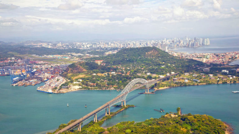 Luftaufnahme der Bridge of the Americas über dem Panamakanal, die den Hafen und die Skyline von Panama-Stadt verbindet.