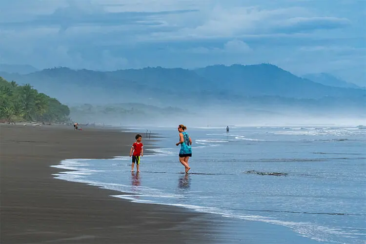 Besucher die am Playa Matapalo spielen.