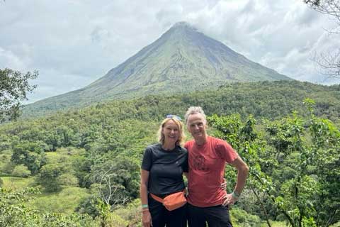 Die Kunden Christine und Andreas S. stehen vor dem Vulkan Arenal in Costa Rica – eine Aufnahme während ihrer Mietwagenrundreise