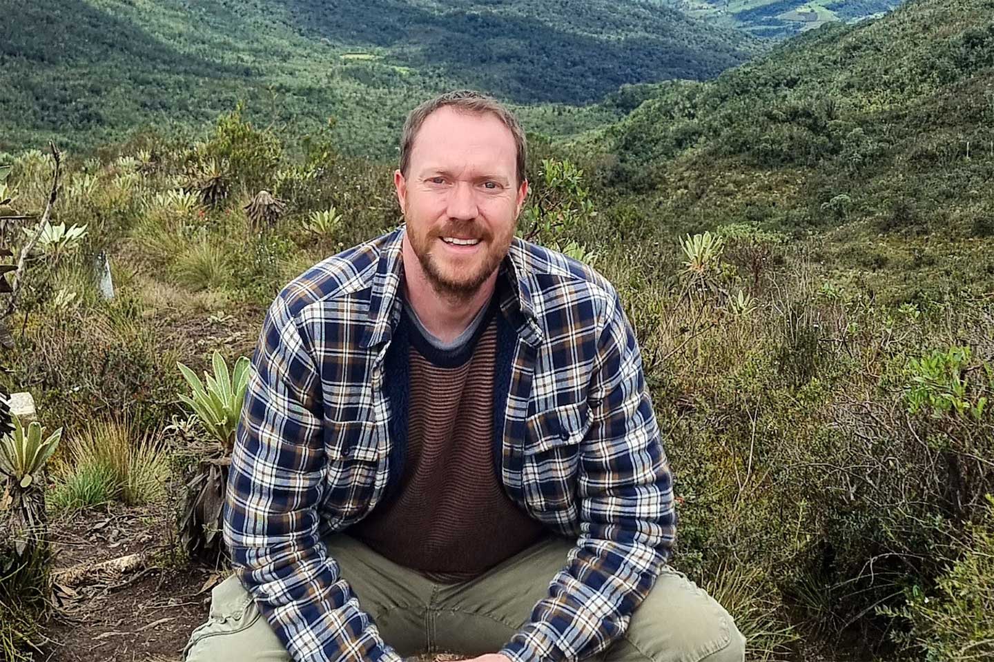 Stephan Stober blickt in die Kamera. Im Hintergrund eine hügelige Landschaft.