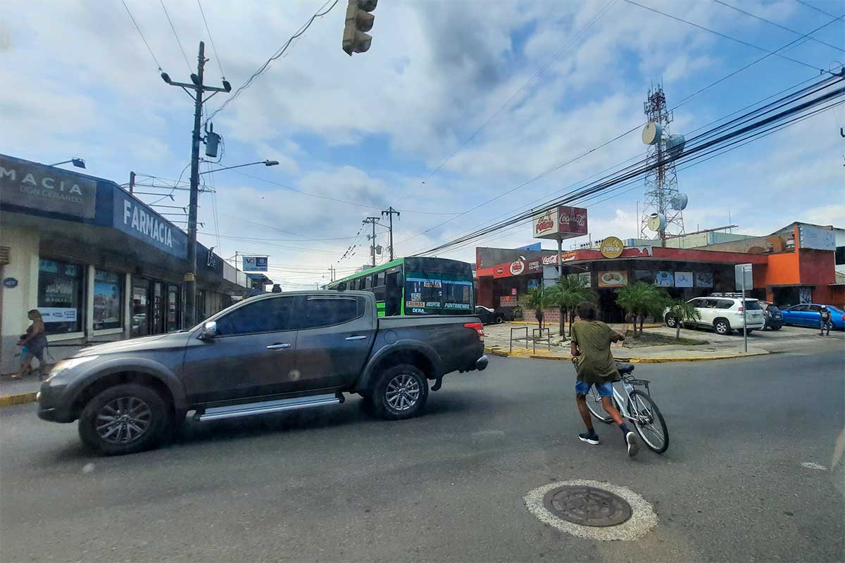 Typisches Verkehrsbild: Ein Jeep rollt entspannt über die Straße, ein Fahrradfahrer kreuzt Weg.