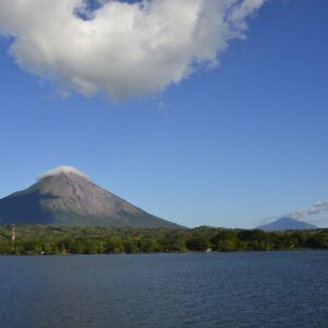 Der Vulkan Concepción auf der Insel Ometepe erhebt sich hinter der bewaldeten Küste des Nicaragua-Sees unter blauem Himmel.