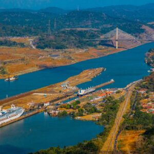 Luftaufnahme der Pedro-Miguel-Schleusen des Panamakanals in Panama mit Schiffsverkehr und der Puente Centenario im Hintergrund.